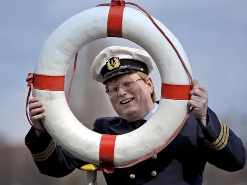 Kapitän mit Rettungsring vor dem Gesicht