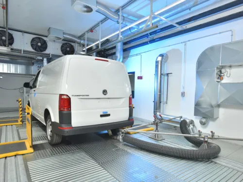 Transporter von Volkswagen in Halle mit Schlauch am Auspuff.