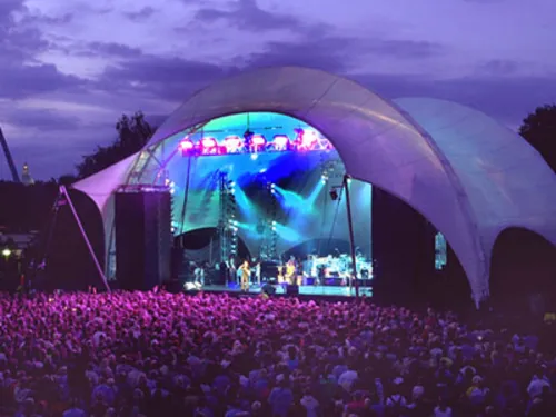 Eine Open Air-Bühne bei Nacht erleuchtet.