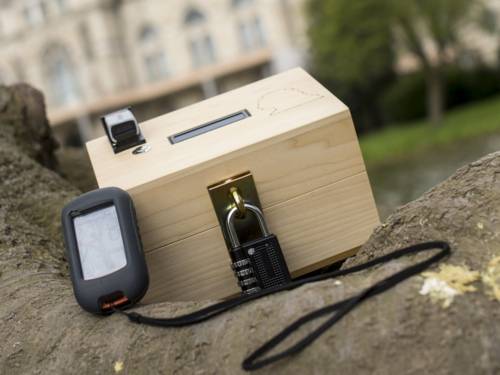 Holzbox mit Zahlenschloss und kleinen elektronischem Gerät