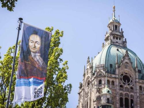 Fahne mit einem Bildnis Leibniz' weht vor der Rathauskuppel.