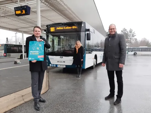 3 Menschen stehen vor einem Bus