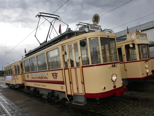 Drei alte Straßenbahnen.