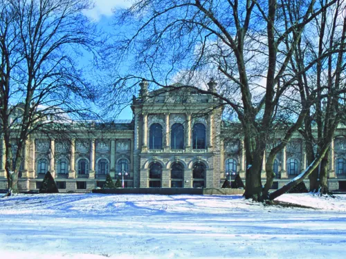 Geb&auml;ude mit B&auml;umen und Schnee