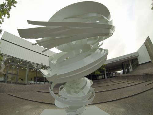 White sculpture in front of a building.