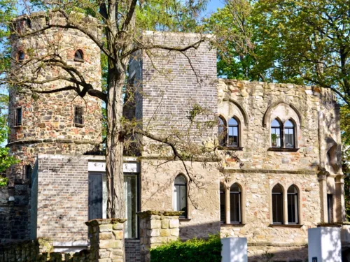 Burgähnliches Gebäude hinter Bäumen