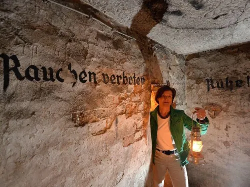 Frau mit Lampe in einem Gewölbekeller