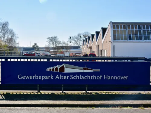 Gebäude-Ensemble, davor ein Schild mit der Aufschrift "Gewerbepark Alter Schlachthof"