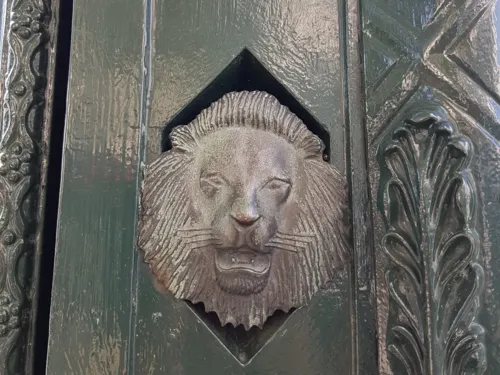 Kleine Löwenfigur auf dunkelgrünem Untergrund
