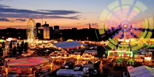 Blick auf einen bunt beleuchteten Jahrmarkt.