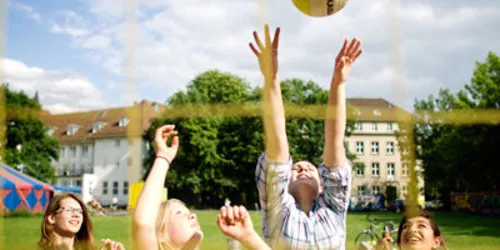Jugendliche spielen Beachvolleyball.