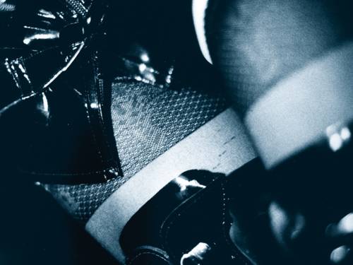 Schwarz-weiss Motiv: Frauenoberschenkel mit schwarzer Strumpfhose, Lackstiefeln und Lackrock 
