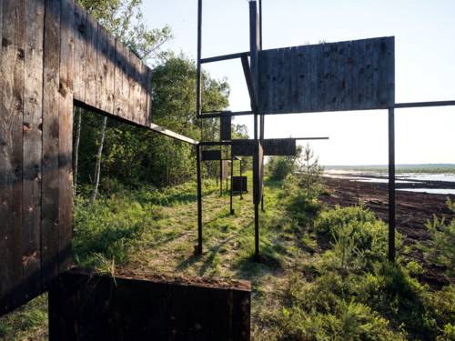 Installation mit geometrisch angeordneten Linien und Flächen in der Moorvegetation.