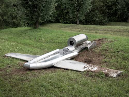 Die silbrige "Schlauchbootdrohne" ARGO scheint abgestürzt zu sein, sie liegt auf einer Grasfläche, der Boden hinter ihr ist aufgewühlt.