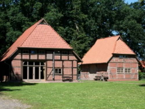 Zwei Fachwerkgebäude stehen nebeneinander, dahinter sind Bäume.