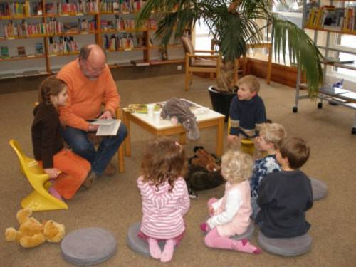 Ein Erwachsener liest kleinen Kindern vor