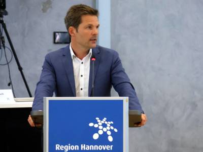 Regionspräsident Steffen Krach redet an einem Rednerpult