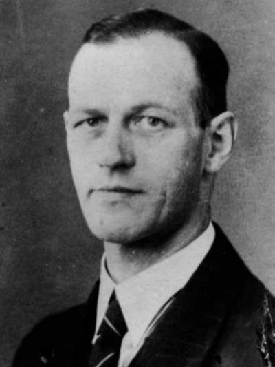 Alte Portraitaufnahme (schwarz-weiß) eines Mannes im Anzug.