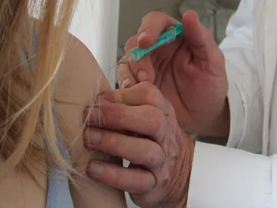 Eine weibliche Person wird in den Oberarm geimpft