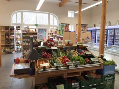 Ein Ladengeschäft von Innen mit Gemüse, Kühlbereich und sonstigenAngeboten