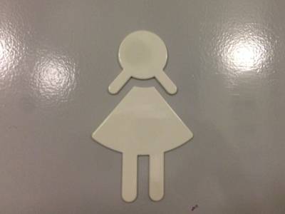 Die Tür eine Damentoilette ist mit einem Schild gekennzeichnet, das die stilisierte Form einer Frau hat.