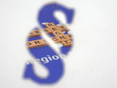 Blick durch einen Paragrafen: Bausteine mit Buchstaben liegen auf einem blauen Hintergrund, sie bilden die Worte "Recht", "Vorschrift" und "Gesetz".