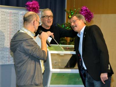 Bezirksbürgermeister Harry Grunenberg (re.) zieht mit geschlossenen Augen das Gewinnerlos für den Hauptpreis der diesjährigen Stiftungs-Lotterie.