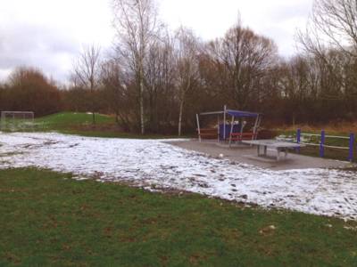 Grünzug Königsberger Ring. Zu sehen ist eine Unterstellmöglichkeit, eine Tischtennisplatte und eine Rasenfläche. Der Rasen ist mit Schnee bedeckt.