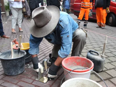 Der K&uuml;nstler Gunter Demnig l&auml;sst die Stolpersteine in Kooperation mit dem Fachbereich Tiefbau der LHH in den Fu&szlig;weg ein.