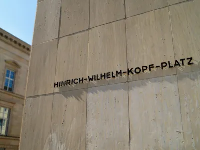 Der Schriftzug "Hinrich-Wilhelm-Kopf-Platz" an einer H&auml;userfassade.