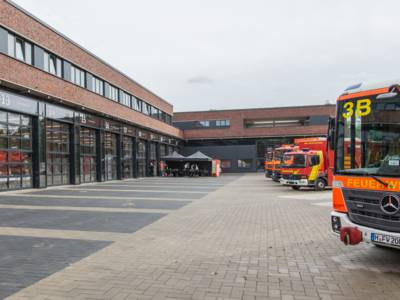 Au&szlig;enansicht der Feuer- und Rettungswache 3, Backsteinbau, im Vordergrund der Frontbereich eines Feuerwehreinsatzfahrzeugs