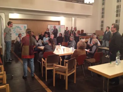 Miteinander diskutierende Personen - teils sitzend, teils stehend