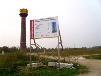 Conti-Schornstein mit Wasserbeh&auml;lter, im Bildvordergrund ein Bauschild 