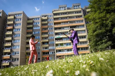 Zwei Musiker, vor einem Hochhaus spielend.