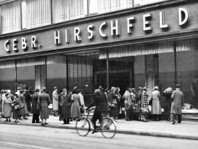 Schwarz-Weiß-Bild eines Geschäfts in der Karmaschstraße, an dessen Fassade "Gebrüder Hirschfeld" steht.