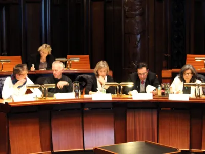 F&uuml;nf Personen sitzen im Hodlersaal nebeneinander hinter Pulten.