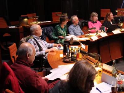 Sieben Personen sitzen im Viertelkreis hinter Pulten im Hodlersaal
