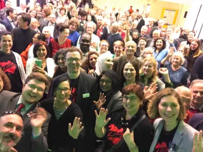 Etwa 100 Personen stehen dicht gedr&auml;ngt im Europasaal des Hauses der Jugend und posieren f&uuml;r's Foto.