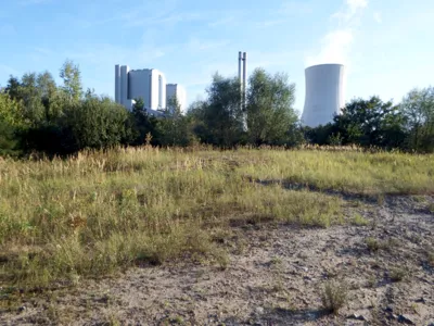 Eine Brachfl&auml;che vor einem Kraftwerk mit K&uuml;hlturm