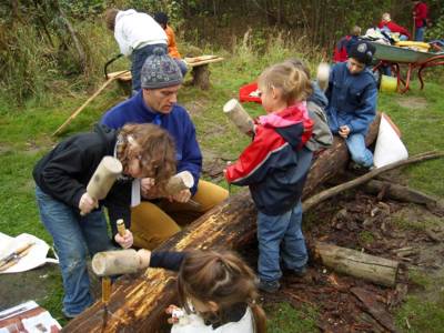 Kinder mit einem Betreuer bei der Holzbearbeitung