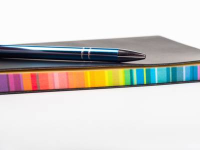 Ein Kugelschreiber liegt griffbereit auf einem farbigen Block