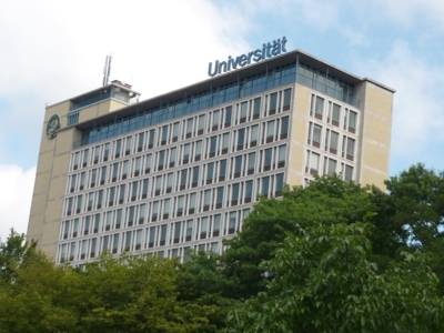 Blaue Buchstaben auf dem Dach des Conti-Campus formen das Wort Universität