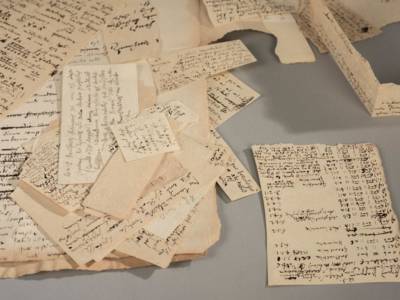 Mehrere Papierschnipsel mit einer altertümlichen Schrift.