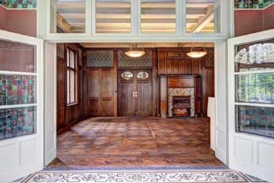 Blick aus einem Wintergarten in einen Raum mit Holztäfelung