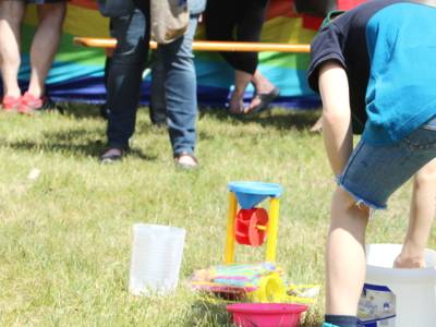 Ein Kind spiel mit Gartenspielzeug auf einer Wiese.