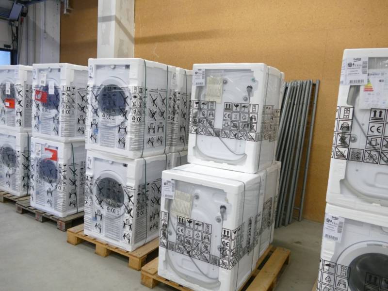 Gestapelte verpackte Ger&auml;te auf Holzpaletten.