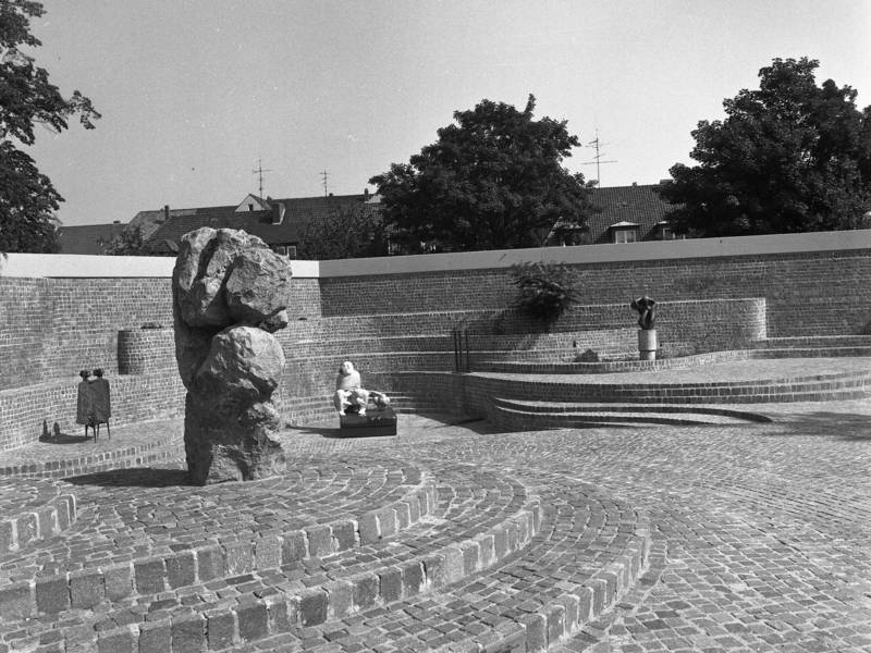 Eine schwarz-weiß Aufnahme, die einen Hof mit Skulpturen zeigt.