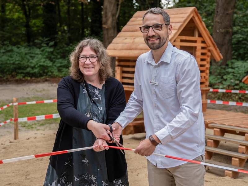 Zwei Personen beim Durchschneiden eines Bands.