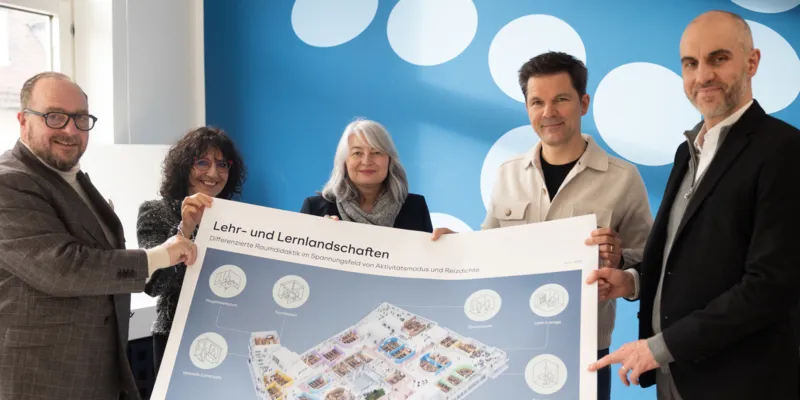 Fünf Personen präsentieren einen Plan.
