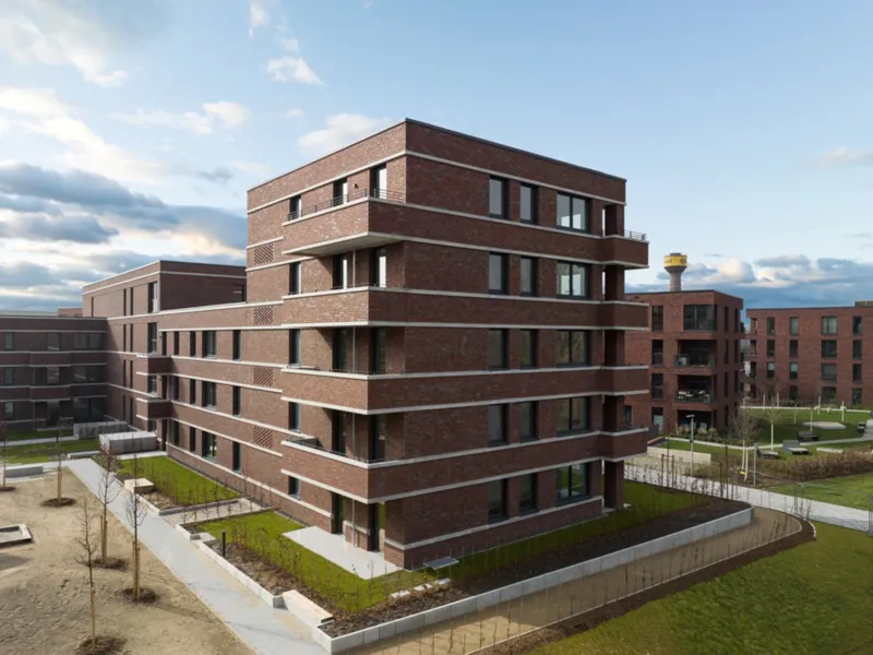 Ein neues Geb&auml;ude mit vier Stockwerken in roten Klinkern.